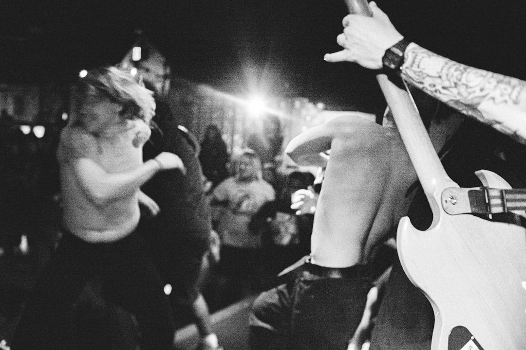 Schwarzweiße Punkrock-Szene mit Sänger, Publikum und E-Gitarre